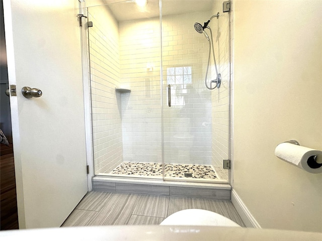 full bathroom featuring a stall shower and baseboards