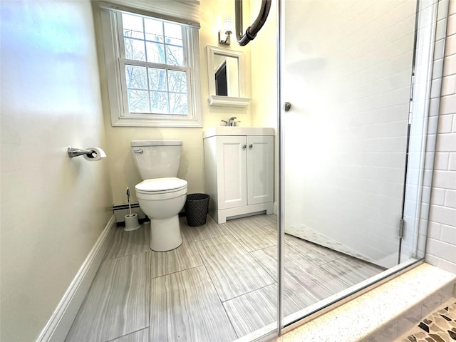 bathroom featuring tiled shower, toilet, baseboard heating, vanity, and baseboards