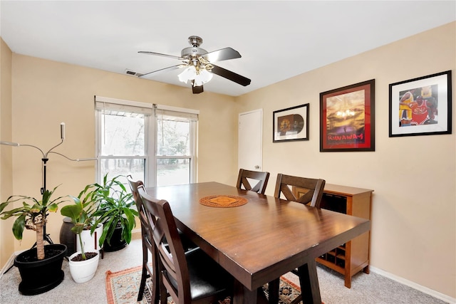 dining area featuring a ceiling fan, baseboards, and light carpet