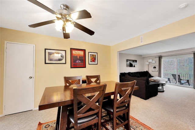 carpeted dining room with ceiling fan