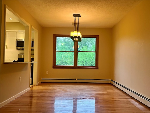 51 Pine Ct, Middletown, NY 10941 - unfurnished dining area featuring a chandelier, wood finished floors, a baseboard heating unit, and a textured ceiling