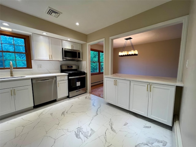 51 Pine Ct, Middletown, NY 10941 - kitchen with appliances with stainless steel finishes, a sink, baseboard heating, light marble finish flooring, and light countertops