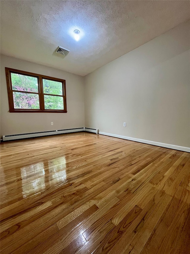 51 Pine Ct, Middletown, NY 10941 - empty room with light wood-style flooring, a textured ceiling, baseboards, and a baseboard heating unit