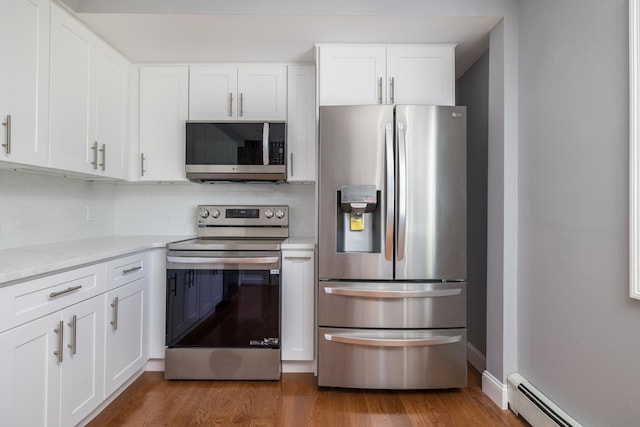 13 Curve Ln, Levittown, NY 11756 - kitchen featuring appliances with stainless steel finishes, a baseboard radiator, decorative backsplash, light countertops, and white cabinets