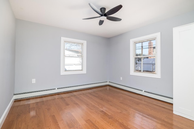 13 Curve Ln, Levittown, NY 11756 - unfurnished room with healthy amount of natural light, a baseboard heating unit, wood finished floors, and a ceiling fan