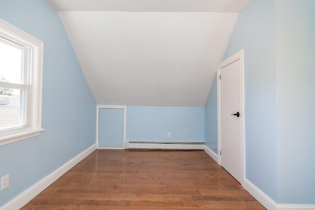 13 Curve Ln, Levittown, NY 11756 - additional living space featuring lofted ceiling, a baseboard radiator, wood finished floors, and baseboards