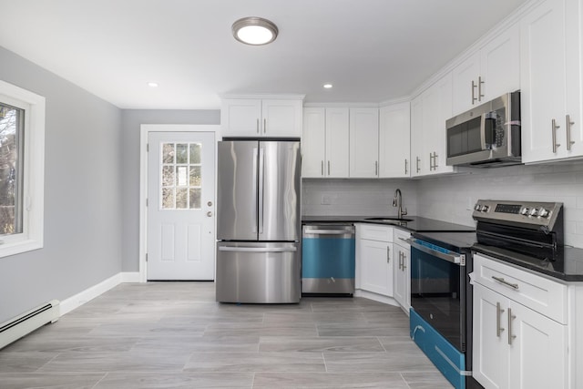 13 Curve Ln, Levittown, NY 11756 - kitchen with stainless steel appliances, dark countertops, healthy amount of natural light, a baseboard heating unit, and recessed lighting