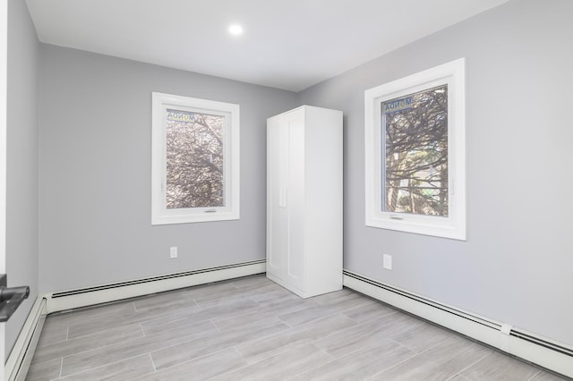 13 Curve Ln, Levittown, NY 11756 - empty room featuring baseboard heating, light wood finished floors, and recessed lighting