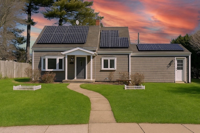 13 Curve Ln, Levittown, NY 11756 - view of front of house with a chimney, roof mounted solar panels, and a shingled roof