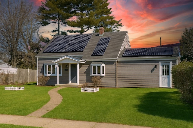 13 Curve Ln, Levittown, NY 11756 - view of front of house featuring a chimney and roof mounted solar panels