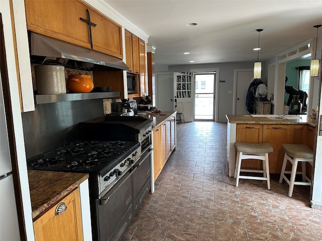 139 Coronado St, Atlantic Beach, NY 11509 - kitchen with black appliances, under cabinet range hood, brown cabinets, dark countertops, and recessed lighting