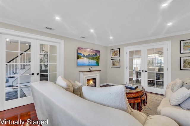 living room with french doors, baseboard heating, recessed lighting, crown molding, and wood finished floors