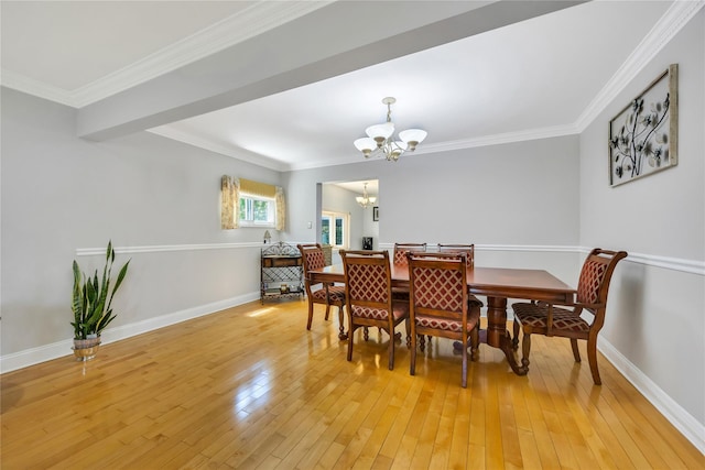 dining room featuring a chandelier, light wood-type flooring, ornamental molding, and baseboards