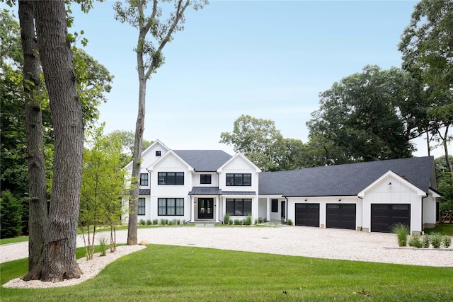 1350 Hortons Ln, Southold, NY 11971 - modern farmhouse style home featuring board and batten siding, an attached garage, driveway, a front yard, and a shingled roof
