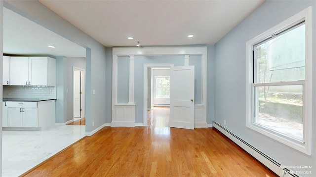 74 Gladstone Ave, Walden, NY 12586 - unfurnished dining area with a baseboard radiator, light wood-style flooring, recessed lighting, and baseboards