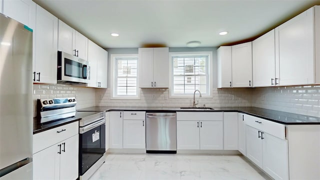 74 Gladstone Ave, Walden, NY 12586 - kitchen with appliances with stainless steel finishes, a sink, light marble finish floors, dark countertops, and recessed lighting