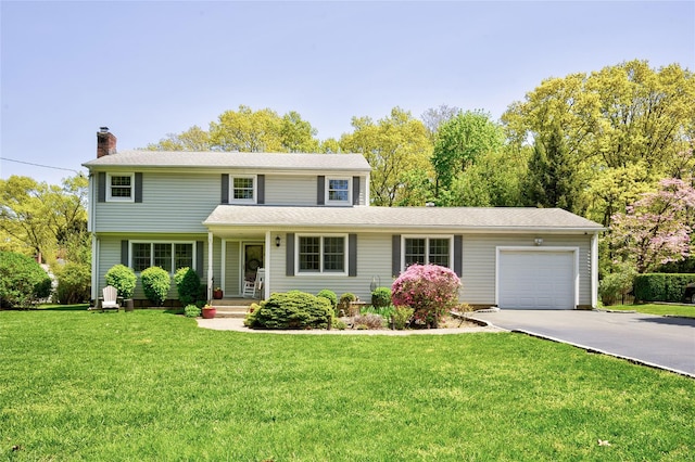 traditional-style house featuring a garage, concrete driveway, a chimney, and a front yard