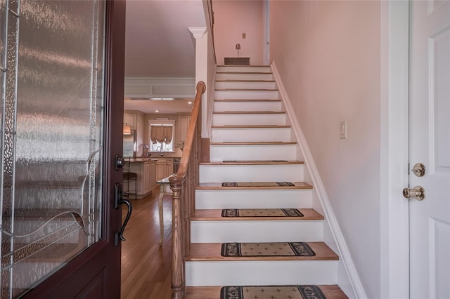 stairway with wood finished floors and baseboards