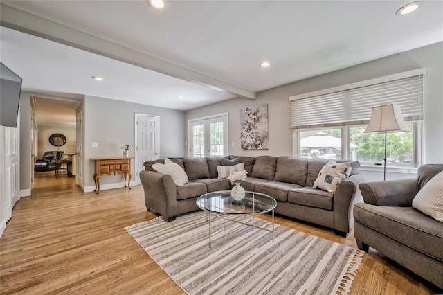 living area featuring light wood finished floors, recessed lighting, baseboards, and beam ceiling