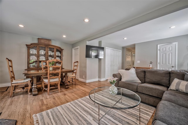 living area with baseboards, light wood-style flooring, and recessed lighting