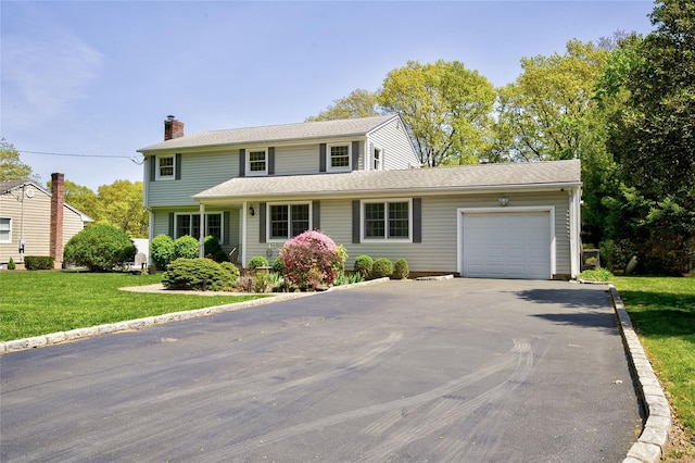 view of front facade featuring asphalt driveway, an attached garage, a chimney, and a front yard