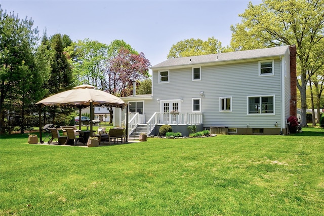 back of property featuring a gazebo, a chimney, a lawn, a deck, and a patio area
