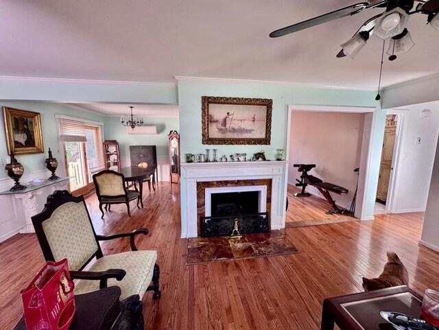 980 Siems Ct, North Bellmore, NY 11710 - living area with ornamental molding, wood finished floors, a ceiling fan, a chandelier, and a tiled fireplace