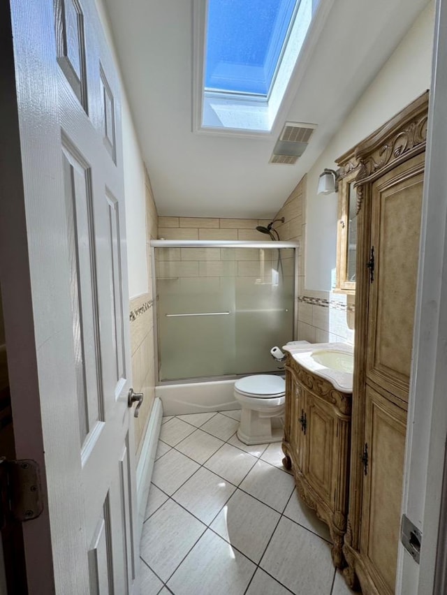 980 Siems Ct, North Bellmore, NY 11710 - full bathroom with a skylight, tile walls, tile patterned flooring, vanity, and combined bath / shower with glass door