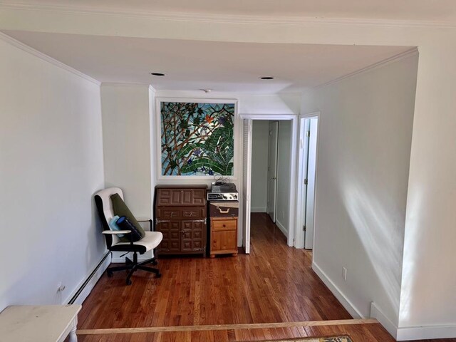 980 Siems Ct, North Bellmore, NY 11710 - living area with baseboard heating, wood finished floors, and crown molding
