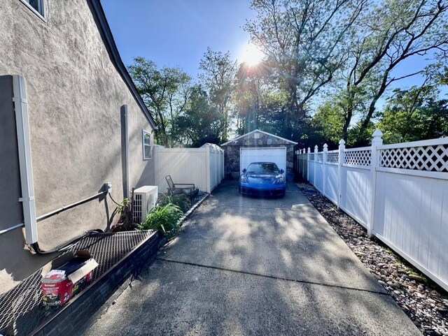 980 Siems Ct, North Bellmore, NY 11710 - view of home's exterior featuring driveway, stucco siding, a garage, fence, and an outdoor structure