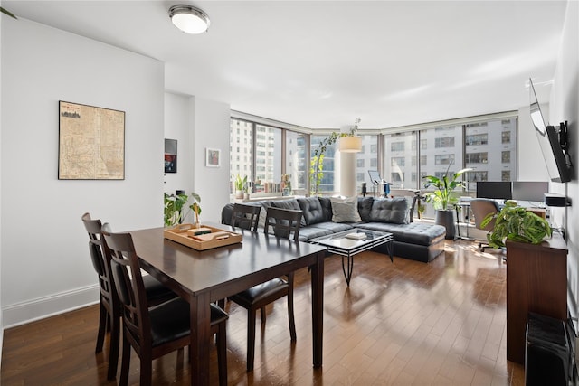 dining room with dark wood-style flooring, baseboards, and floor to ceiling windows