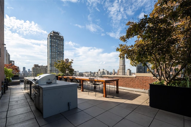 view of patio with a view of skyline, exterior kitchen, area for grilling, and outdoor dining space