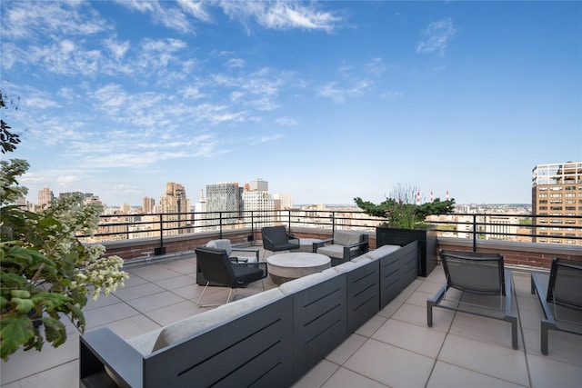 view of patio with an outdoor living space, a city view, and a balcony