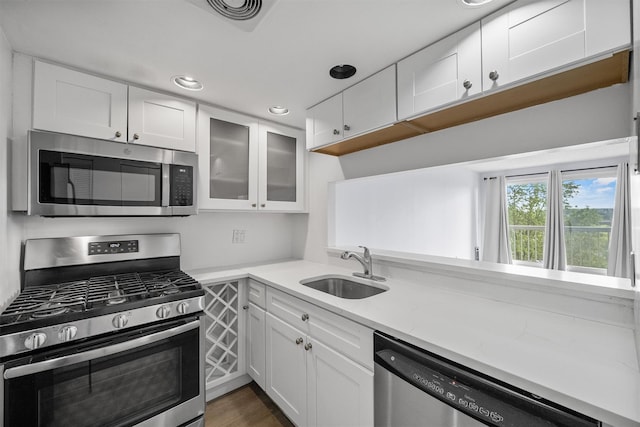 10 Stewart Pl Unit 4De, White Plains, NY 10603 - kitchen with stainless steel appliances, a sink, white cabinets, glass insert cabinets, and recessed lighting