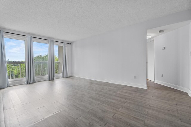 10 Stewart Pl Unit 4De, White Plains, NY 10603 - empty room featuring a textured ceiling, wood finished floors, baseboards, and a smoke detector