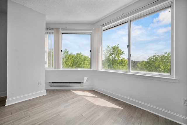 10 Stewart Pl Unit 4De, White Plains, NY 10603 - empty room featuring a baseboard radiator, healthy amount of natural light, and a textured ceiling