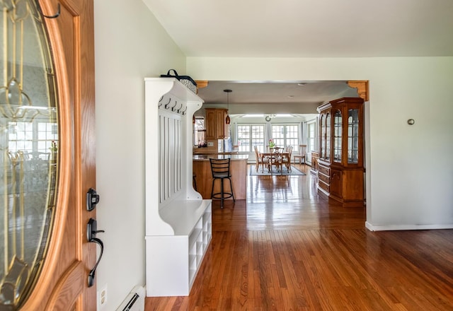 foyer featuring wood finished floors, a baseboard heating unit, and baseboards