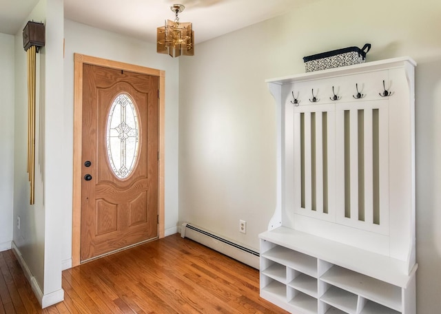 entryway featuring a baseboard heating unit, a chandelier, light wood-style flooring, and baseboards