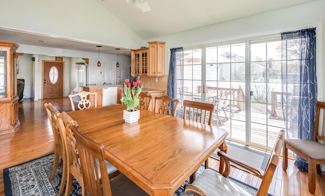 dining room featuring vaulted ceiling and light wood-style flooring