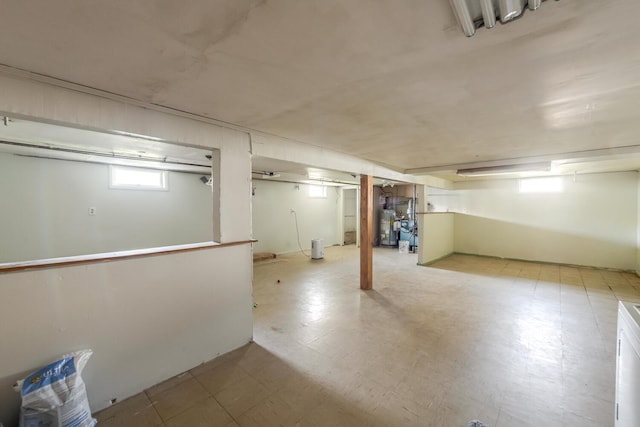 below grade area featuring light flooring and water heater