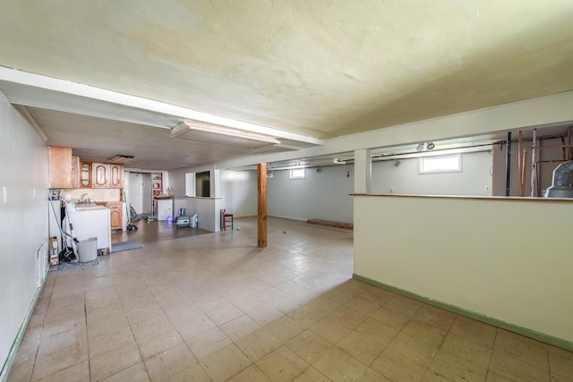 basement with washer / dryer, light floors, and baseboards
