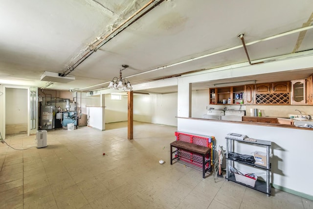 finished basement featuring gas water heater, light flooring, washer / dryer, and a heating unit