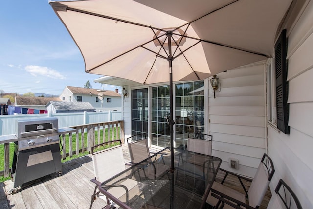 deck featuring fence, outdoor dining area, and grilling area