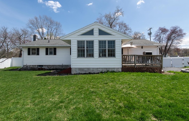 back of house with a deck, a gate, a chimney, and a shingled roof