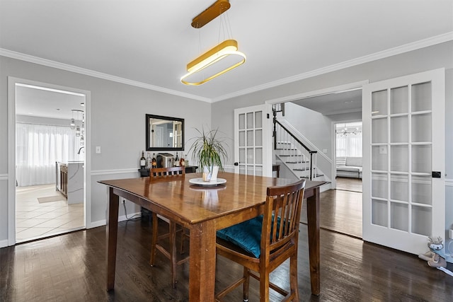 dining space featuring a chandelier, wood finished floors, stairway, plenty of natural light, and ornamental molding