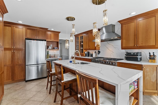 kitchen featuring freestanding refrigerator, a sink, open shelves, brown cabinets, and wall chimney range hood