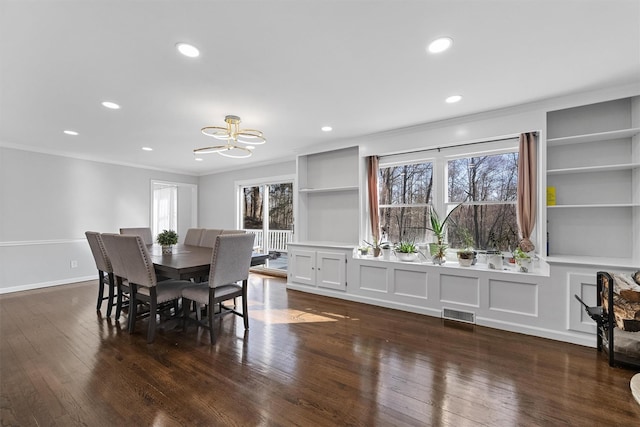 dining space featuring a chandelier, crown molding, healthy amount of natural light, built in features, and recessed lighting