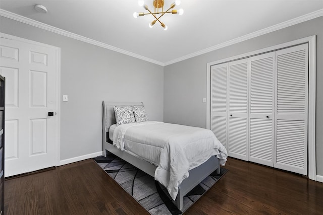 bedroom featuring a chandelier, wood finished floors, baseboards, crown molding, and a closet