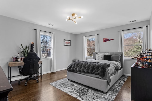bedroom with wood finished floors, a chandelier, and baseboards