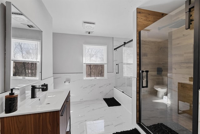 bathroom with toilet, marble finish floors, and vanity